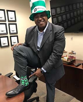 Employee showing off green socks and hat
