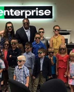 Employees with group of kids in Enterprise office