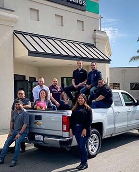 Group of employees in the bed of a truck