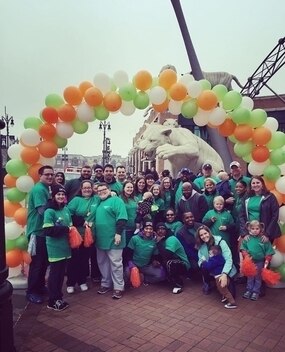 Group of employees under a balloon arch