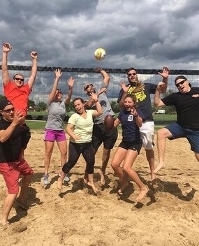 Employees playing sand volleyball