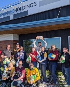 Employee group photo holding frozen turkeys