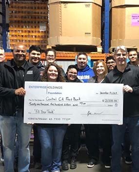 Group of employees holding donation check