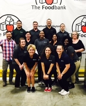 Employee group photo in front of Foodbank banner