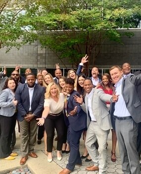 Group of employees with arms outstretched