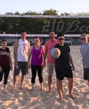 Employees playing sand volleyball