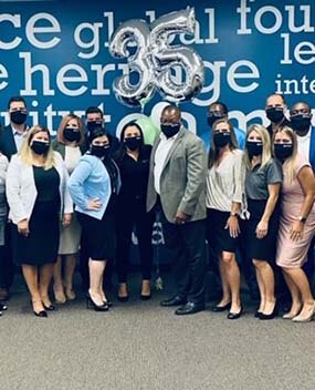 Employee group photo with "35" balloons