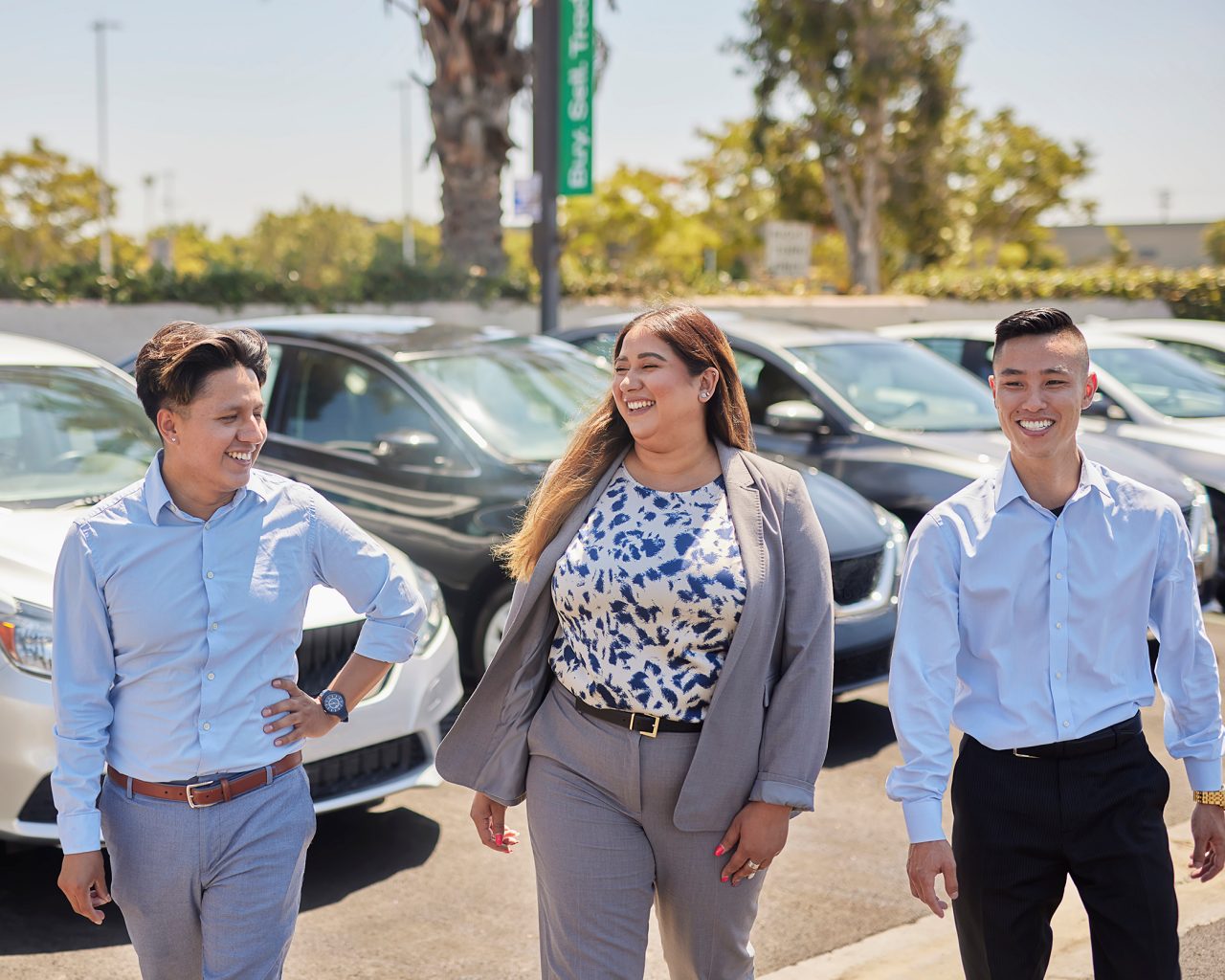 Four Enterprise Mobility team members talking and laughing in front of a local neighborhood retail branch. 