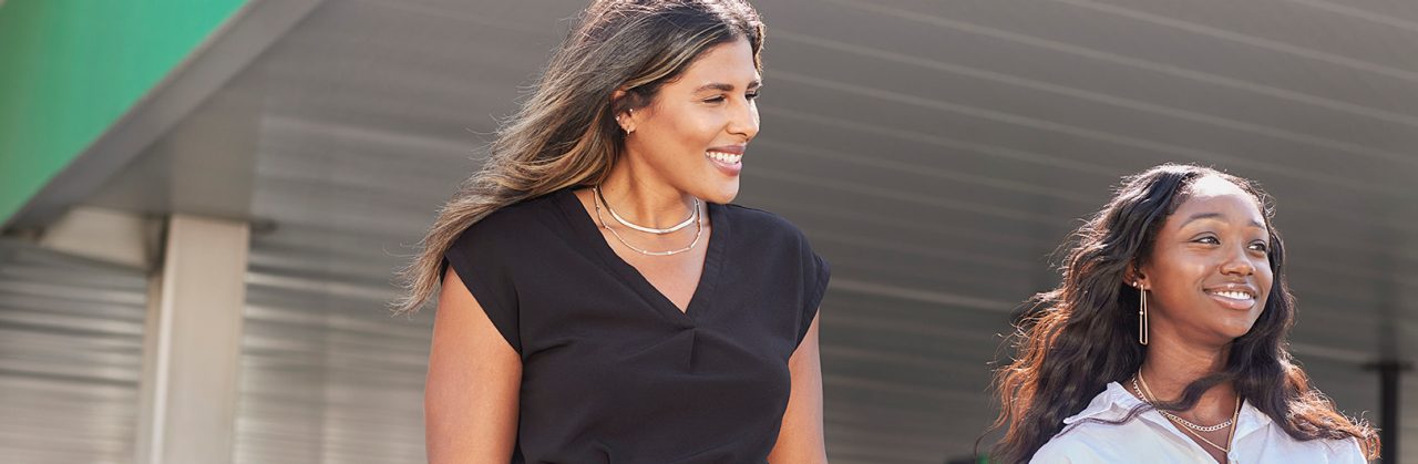 Two Enterprise Mobility team members walking through a car park of a retail branch. 