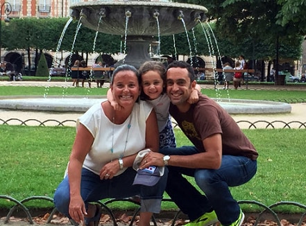 General Manager Bridget L. with her husband and daughter in front of a fountain
