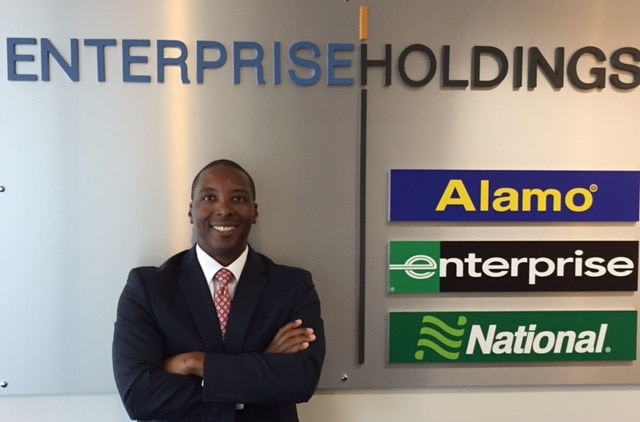 Art Turner in front of Enterprise Holdings sign with brand names