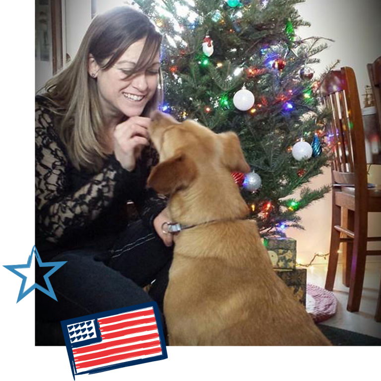 Talia with her dog in front of a Christmas tree