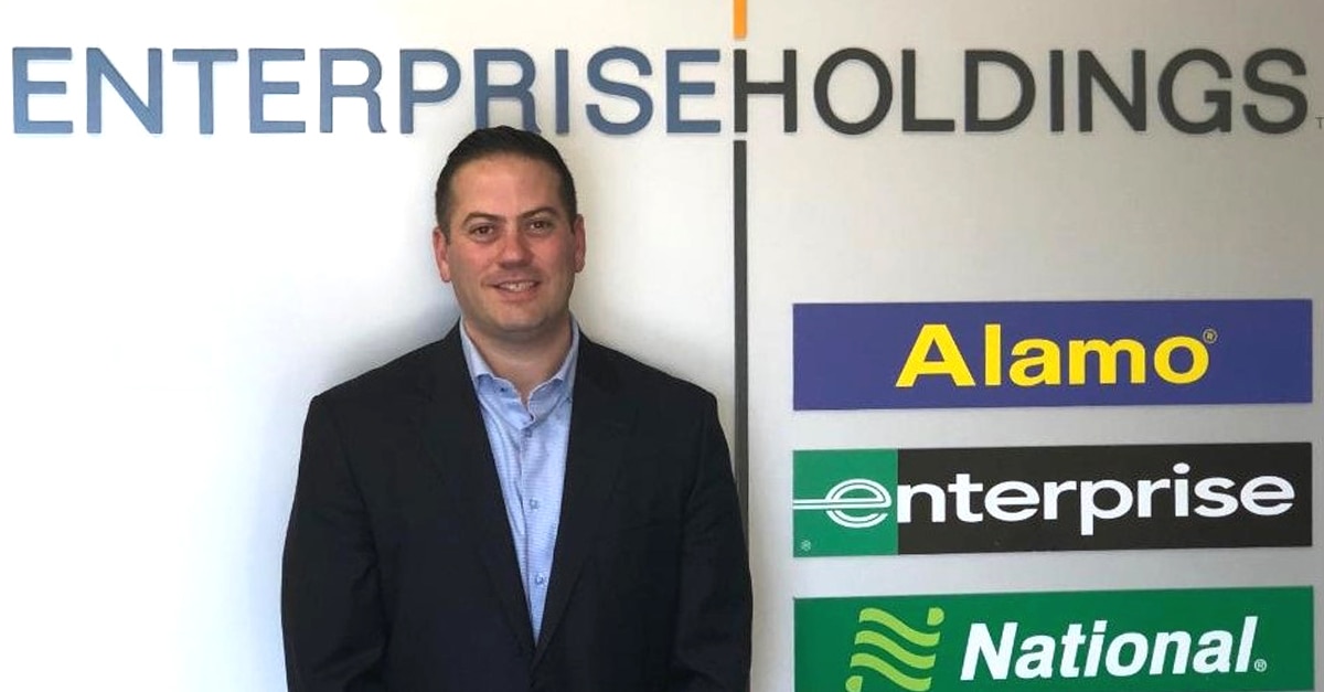 Ethan B in front of Enterprise Holdings sign with brand names