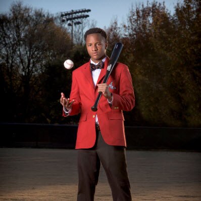 Ty wearing a suit with a baseball and bat