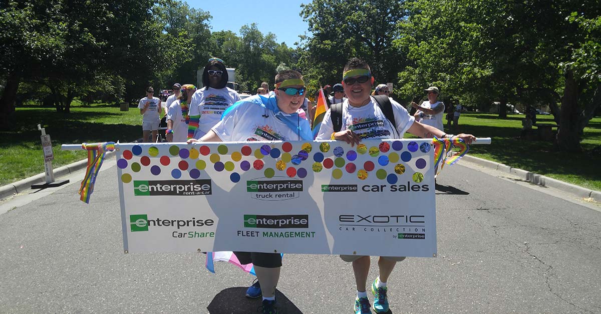 Ace and Amy with an Enterprise banner at a parade