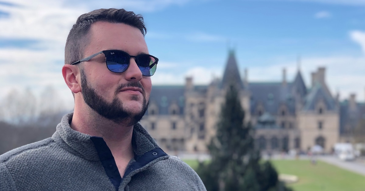 Picture of Adam S. wearing sunglasses in front of a castle