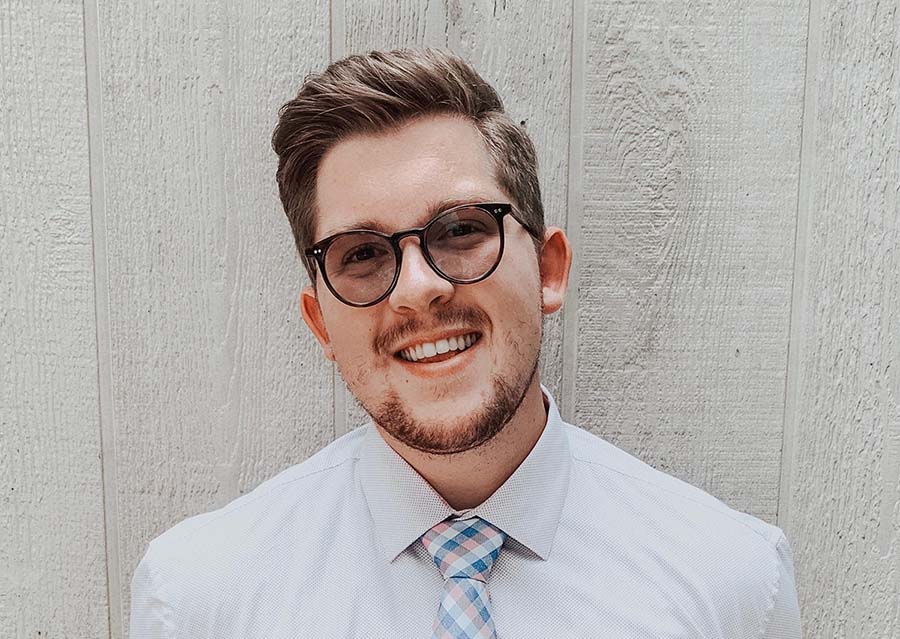 Headshot of Braden E. against white wood wall