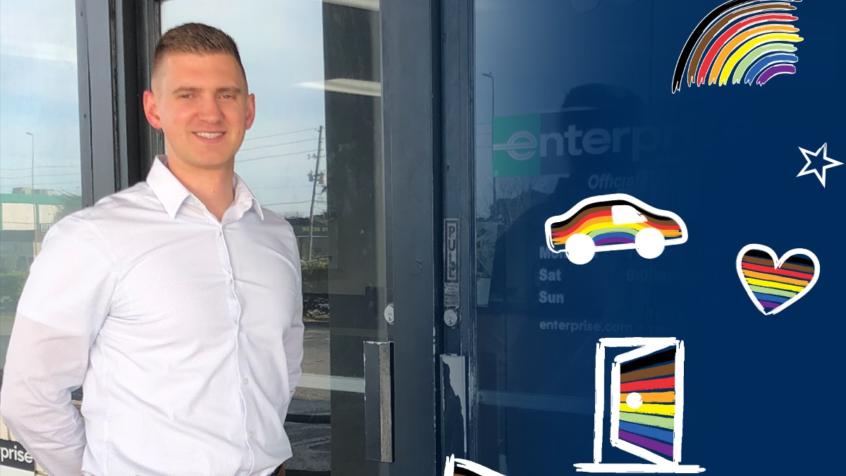 Mirek in front of Enterprise building with rainbow icons