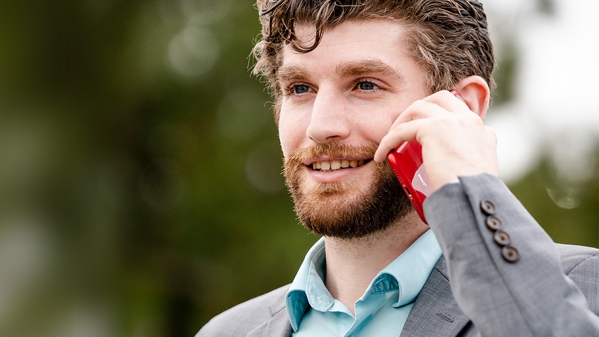Man in suit talking on red cell phone