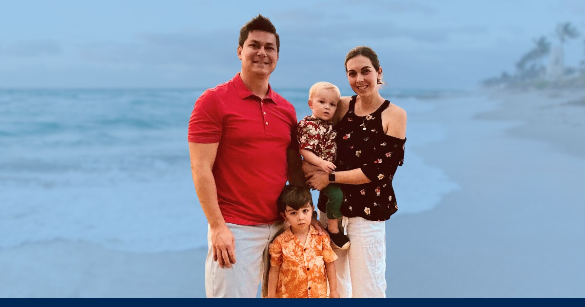 John with his wife and children on a beach