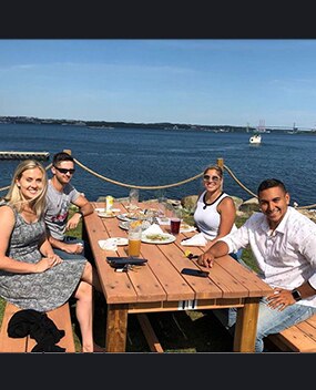 Employees having a meal next to a body of water