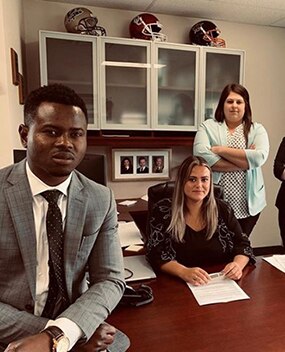 Employees posing at a desk in an office