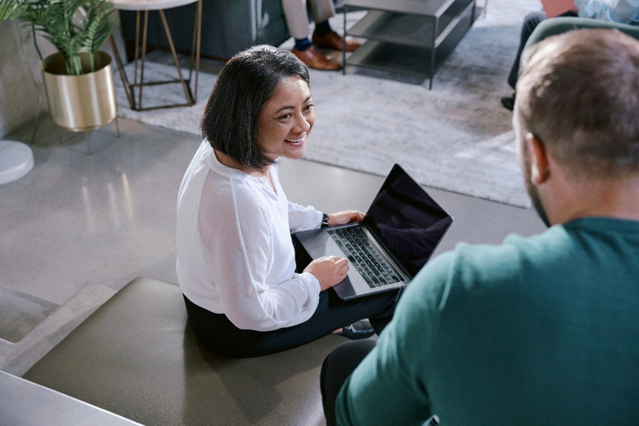 Girl sits down on bench with computer