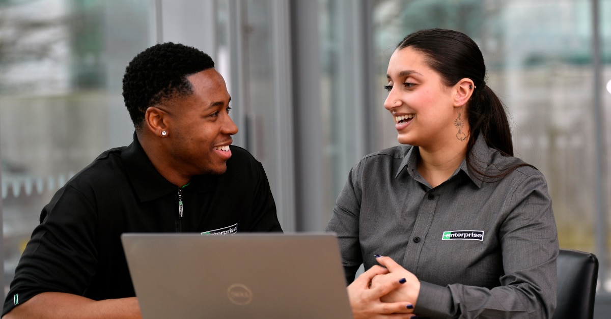 Man and woman sit in front of a laptop computer