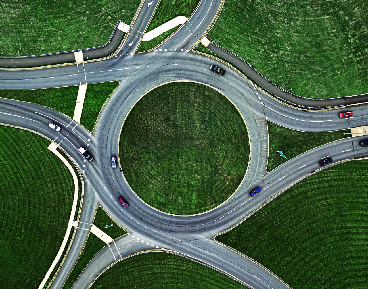 Aerial view of a highway interchange with cars moving on and off the ramps.