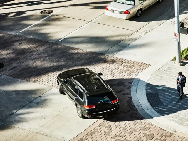 Aerial view of a black luxury SUV pulling out of a driveway.
