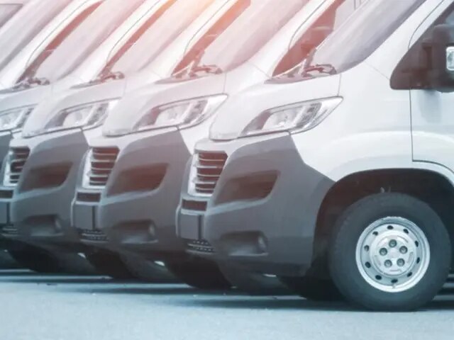 Une longue rangée de fourgonnettes de tourisme blanches.